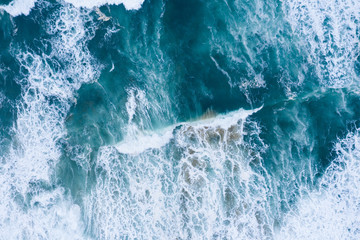 Blue ocean waves and sand aerial drone top view