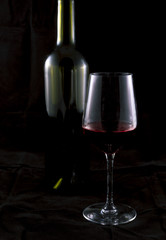 Glass of red wine and bottle