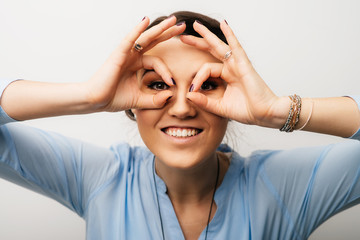 Pretty brunette girl shows glasses hands