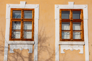Obraz premium closed and open window of an old wooden house, traditional brown and red
