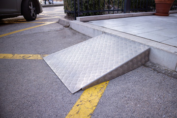 Ramp for disabled persons on wheelchair at building entrance.