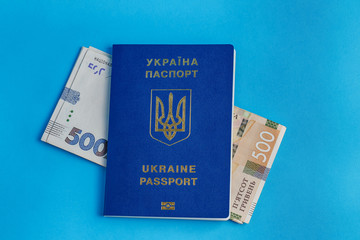 lies a banknote of 500 hryvnias at the top Ukrainian passport abroad on a blue background close-up traveling business