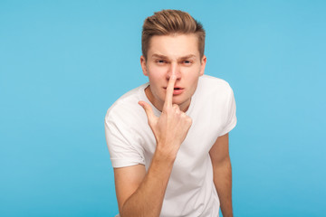 You are liar! Portrait of man in t-shirt peeking angrily into camera and touching his nose, showing...