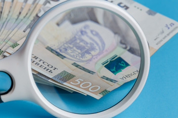 Deck 500 hryvnias deck through a magnifying glass close-up blue background