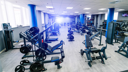 Fototapeta na wymiar Empty fitness center hall. Modern and empty gym interior with equipment. Different sport equipment in modern gym. Closeup