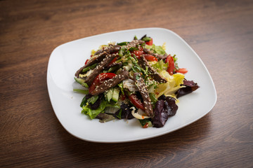 Fresh salad with grilled beef , arugula and tomato. Top view