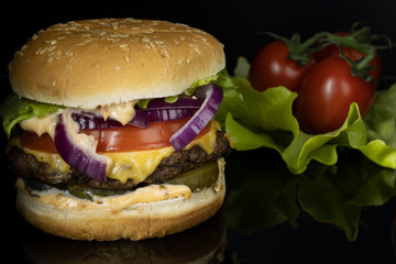 fresh hamburger and tomatoes on a dark background
