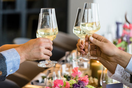 Die H&auml;nde zweier Paare in Tracht prosten sich mit Sektgl&auml;sern zu