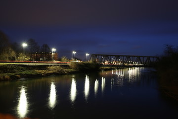 Fototapeta na wymiar Ponte sul fiume illuminato dalle luci dei lampioni led a risparmio energetico