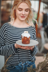 Easter cake in the hands of a beautiful smiling girl