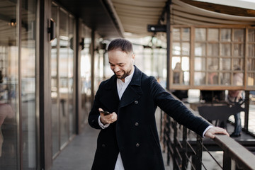 Fototapeta premium Portrait of fashionable well dressed man with beard posing outdoors