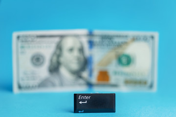 enter button in the foreground blurred banknote one hundred dollars centered on a turquoise background