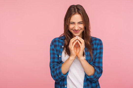 Portrait of sneaky scheming young woman in checkered shirt thinking devious plan with cunning evil face expression, having slyly idea to prank friend. indoor studio shot isolated on pink background