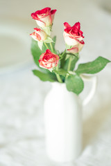 Bouquet di roselline in vaso bianco