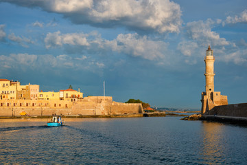 Fototapeta premium Fishing boat going to sea in picturesque old port of Chania is one of landmarks and tourist destinations of Crete island in the morning. Chania, Crete, Greece