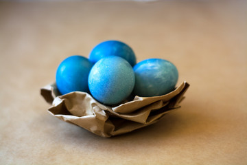 Easter holiday decorations, background. Basket with painted blue eggs, with bars, branches, flowers. Religion.