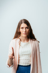 long-haired beautiful brunette girl prohibits or prevents the finger, isolated on a white background