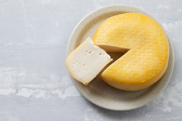 round cheese on dish on ceramic background