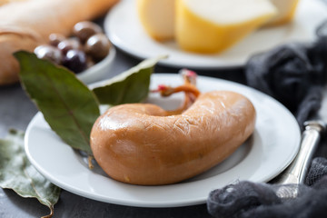 typical portuguese smoked sausage farinheira, olives and bread on white dish