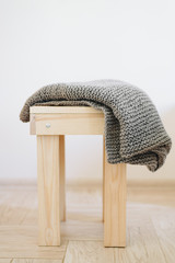 Handmade knitted blanket on a wooden chair
