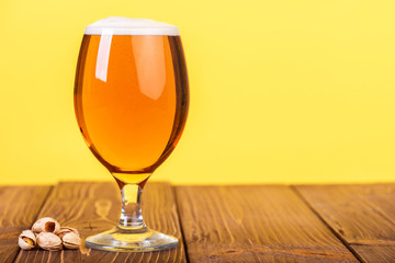 Glass of beer on color background.