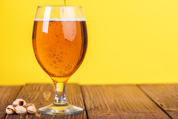 Glass of beer on color background.