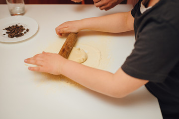 Cooking home. Mother and son baking together at home. Close-up of rolling dough