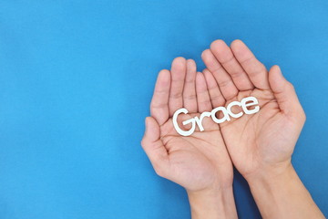 Male hands praying for grace from God in blue background. Top view with copy space.