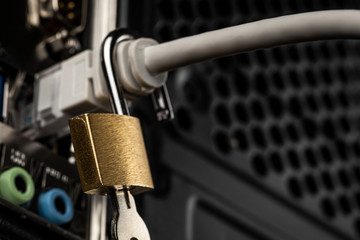 Opened lock hanging on a network cable plugged into a computer. The concept of opening access,...