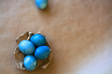 Easter holiday decorations, background. Basket with painted blue eggs, with bars, branches, flowers. Religion.