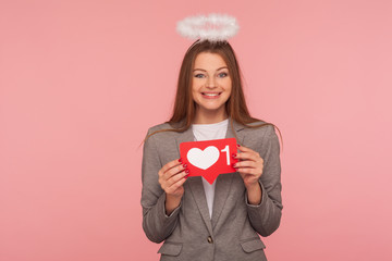 Portrait of adorable brunette woman with nimbus in business suit holding network heart Like icon...