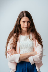 on a gray background young girl angry and folded her hands