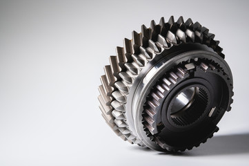New parts on a gray background. Gears of gear shifting torque transmission. Conceptually mechanical background. Shiny gear box gear teeth