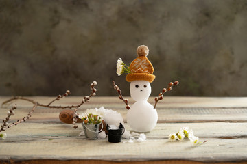 the spring equinox  or hello spring concept. Funny card with little snowman and melted snow in...