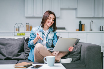 Young woman celebrating money win after making bets online at bookmakers website using her laptop