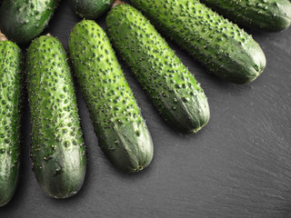 Green ripe cucumbers on black plate