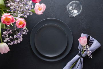 Obraz na płótnie Canvas Easter elegance table setting spring pink tulip on black. Home dinner. Top view.