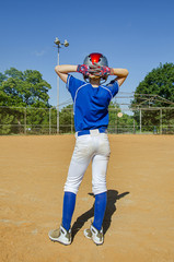Male youth baseball player standing on the field