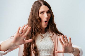 long-haired beautiful brunette girl holding hands at a distance, asked to calm down, isolated on a...