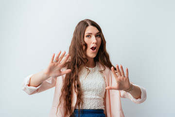 long-haired beautiful brunette girl holding hands at a distance, asked to calm down, isolated on a white background