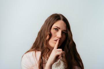 Naklejka premium long-haired beautiful brunette girl asks quiet, isolated on a white background