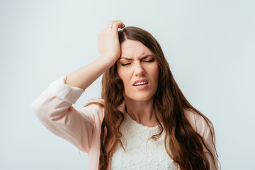 Fototapeta premium long-haired beautiful young brunette woman headache and holding on to the left side of the head