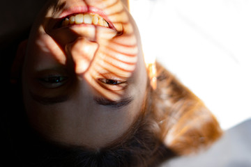 Woman with shadows and sunlight on her face.