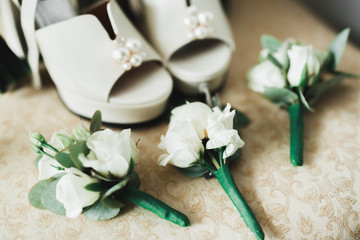Fototapeta na wymiar Pair of elegant and stylish bridal shoes with a bouquet with roses and other flowers