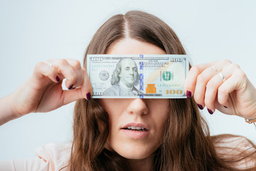 on a gray background young girl with dollars