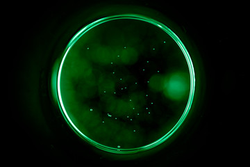 Abstract background with a black hole in green. Sphere on black background.