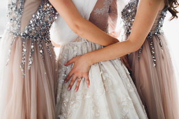 Fototapeta na wymiar Hands of bridesmaids on bridal dress. Happy marriage and bride at wedding day concept