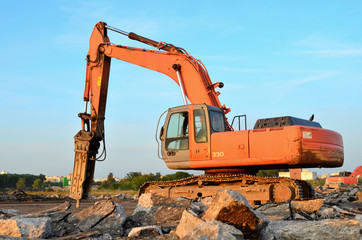 Crawler excavator with hydraulic breaker hammer for the destruction of concrete and hard rock at the construction site or quarry.  Jackhammer using without blasting method. Hard rock demolition