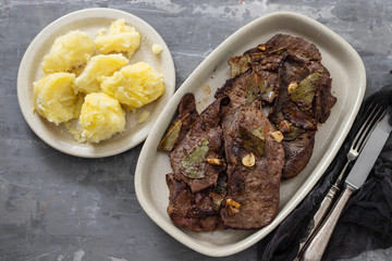 fried liver with garlic on dish on ceramic background