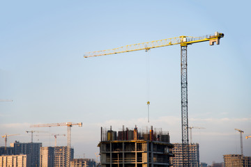 Tower cranes constructing a new building at construction site.